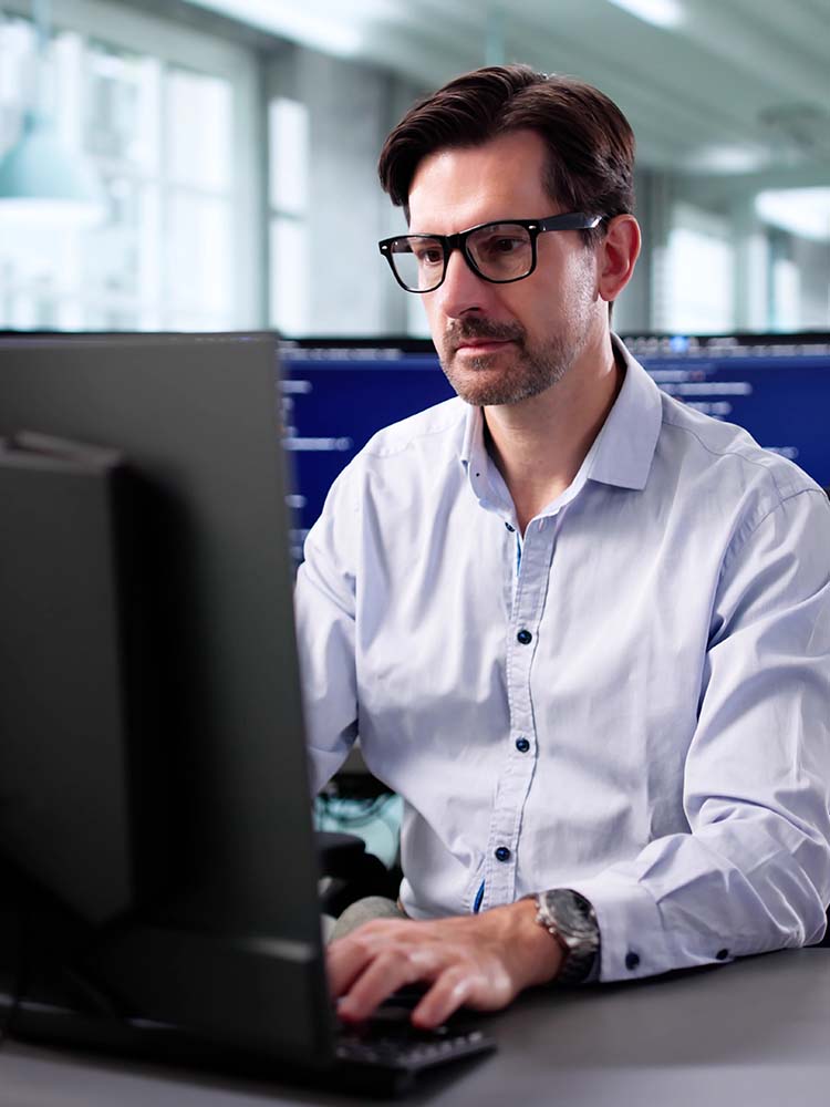 Man facing towards camera working on computer.